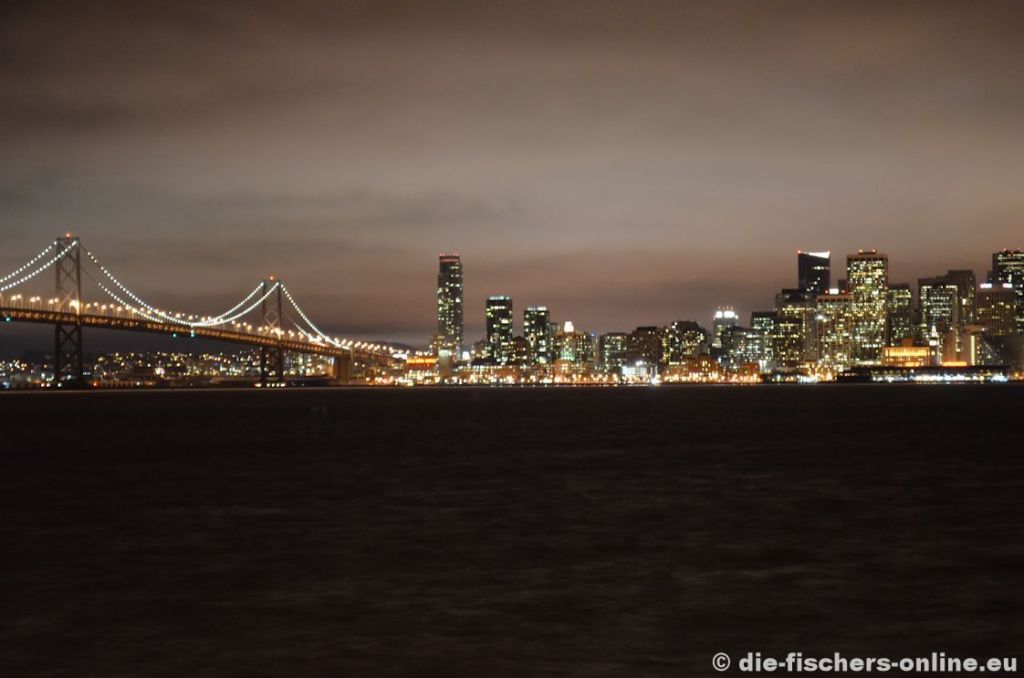 San Francisco: Skyline bei Nacht
Von Treasure Island hat man einen sehr schönen Blick auf San Francisco. Links ist die Bay Bridge zu sehen, eine mehrstöckige Brücke, die auf einer Ebene den Verkehr aus der Stadt bringt und auf einer anderen Ebene den Verkehr in die Stadt leitet.
