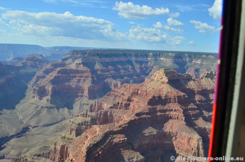 Grand Canyon: Blick zum Tower of Ra
Tief unten im Tal schlÃ¤ngelt sich der Colorado River entlang. Man mag es kaum glauben, aber bis unten sind es bis zu 1.600 Meter! Viele der durch Wind und Wetter geformten Felsen haben Namen aus der Ã¤gyptischen Geschichte. wenn man genau hinsieht kann man sich denken warum: Viele Felsformationen sehen wie Pyramiden aus.
Im Hintergrund befindet sich der Point Sublime, ein Aussichtspunkt der North Rim.
